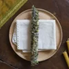 Kadzidlo-naturalne-dobrostan kadzidło ziołowe położone na białej serwetce, pod spodem drewniany talerz